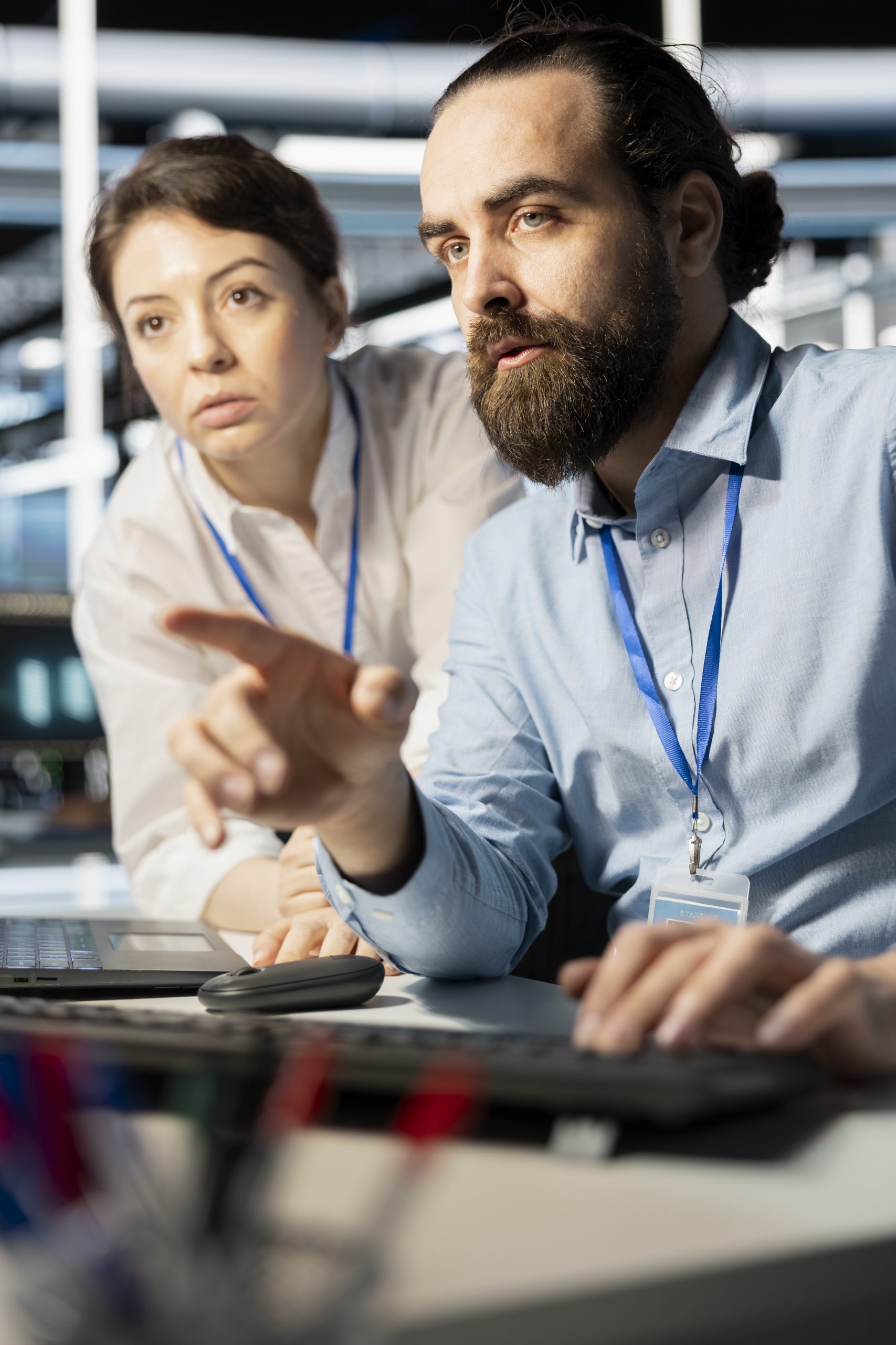 Programmers in data center workplace using computer, verifying firewall configurations. Teamworking colleagues doing brainstorming, performing equipment vulnerability scans in server hub using PC